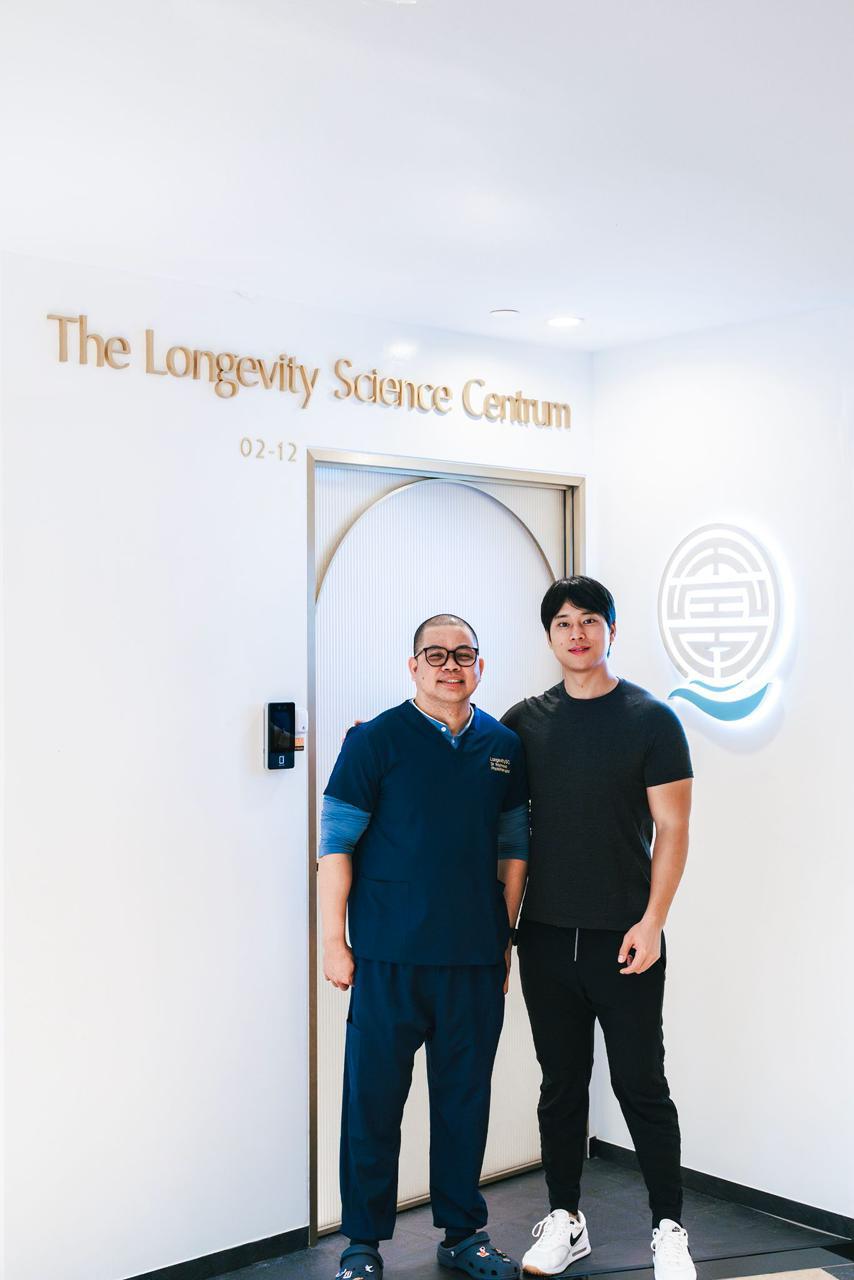 The entrance to The Longevity Science Centrum, its name in gold lettering beside the illuminated emblem.